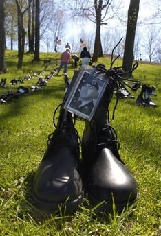 A pair of boots adorned with a photo of Sgt. Lane Tollett of Columbus, Ohio, sits at the base of the May 4, 1970, memorial on the campus of Kent State University Friday, May 4, 2007, as part of an anti-war display. Tollett was killed in Iraq Saturday, April 28, 2007, and anti-war protestors displayed 161 boots in honor of all Ohio soldiers killed in Iraq as part of the annual May 4 remembrance. [AP Photo/Jeff Glidden]